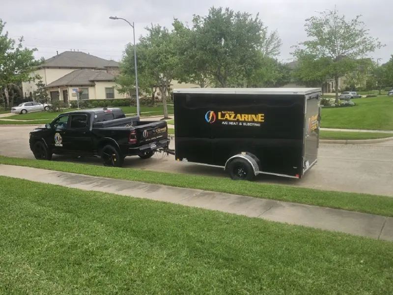 Lazarine AC pickup and branded equipment trailer parked at a customer's home